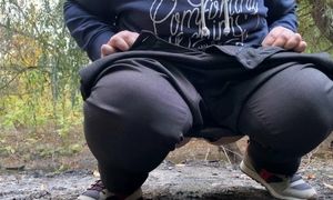 Cougar clad in trousers urinating in public outdoors